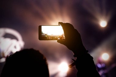 Müzik şovunda akıllı telefon yelpazenin elinde.