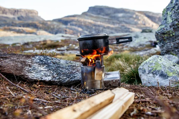Cooking on a small camping stove in a mountain camp