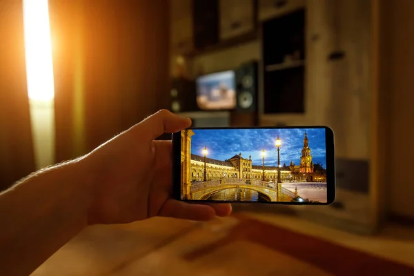 携帯電話を使用して自宅からスペインのセビリアへのオンライン旅行 スマートフォンの画面上のプラザ エスパーナ — ストック写真