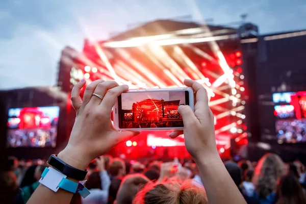 Hands with a smartphone records live music festival, live concert, live concert.