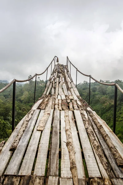 A wooden bridge over the jungle that breaks off at the end, Fog weather