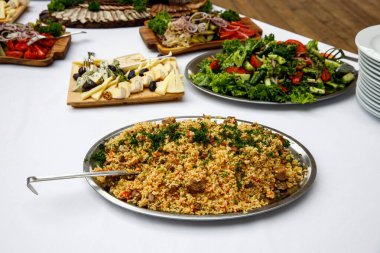 Masanın üzerinde beyaz masa örtüsü olan bir pilav tabağı..