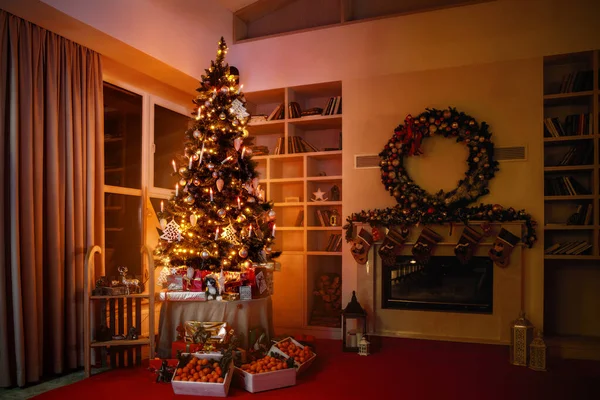 Interior christmas sweet home. Magic glowing tree, fireplace gifts in dark at night