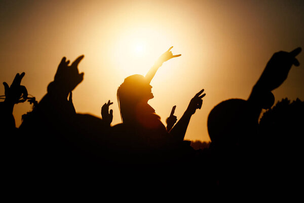 Raised hands of many people at a big mass event.