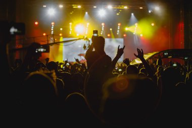 Sahnedeki bir müzikal gösterisinin onuruna ellerini kaldırdı.