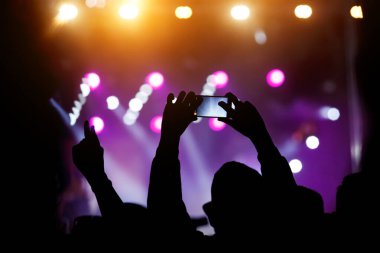 Akıllı telefonlu el, canlı konser sırasında ya kayıt yapmak ya da fotoğraf çekmek için açıldı.
