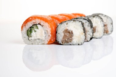 İzole edilmiş beyaz arka planda servis edilen çeşitli suşiler.