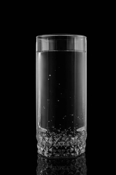 Glass of water on a black background