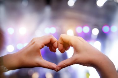 Konser canlı yayınında ellerle yapılan aşk işareti.