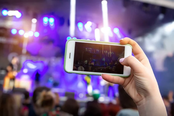 Concert visitor shoots video on a smartphone