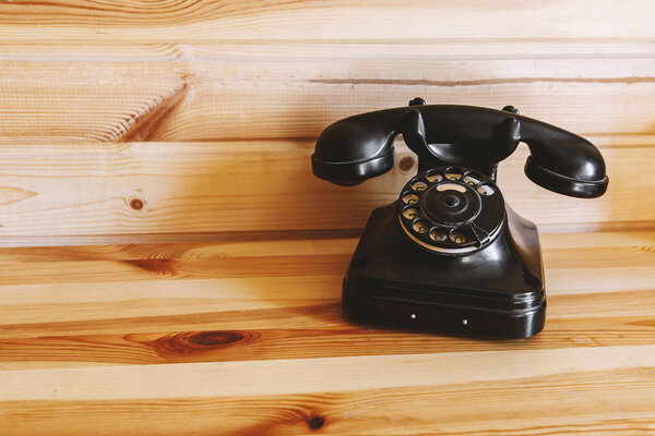 Retro style dial telephone on wooden background