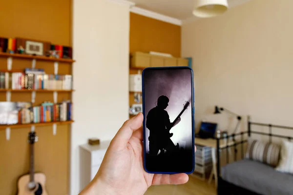 Watching live video concert while staying at home. Guitarist on the screen