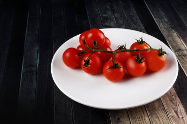 Beyaz yuvarlak tabakta taze kiraz domatesleri..