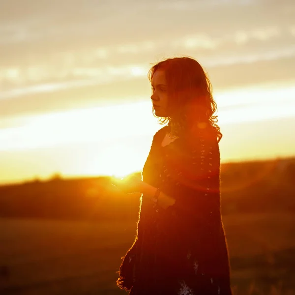 Happy young woman on sunset , outdoor girl in a plaid poncho in a field with spikelets