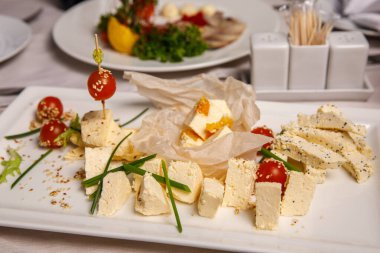 Ziyafet masasında çeşitli peynirler var. Peynir tabağı