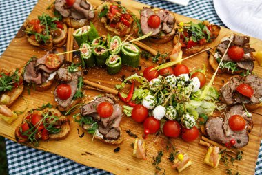 Yemek organizasyonunda çok farklı atıştırmalıklar var. Tahta masa.