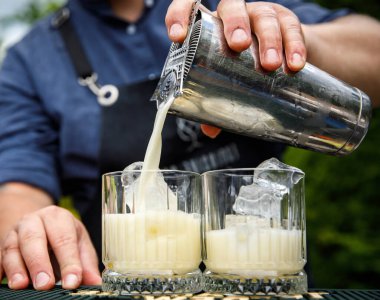 Barmen bardağa buzlu bir kokteyl dolduruyor..