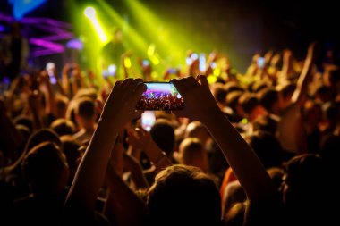 Konserde cep telefonu kullanmak.
