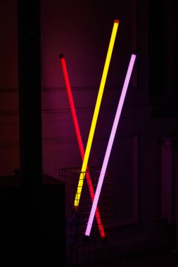 Üç parıldayan ışık tüpü kırmızı, sarı ve menekşe ile karanlık bir iç mekâna yerleştirildi. Parti veya kulüp düzenlemeleri için modern dekorasyon ögesi.