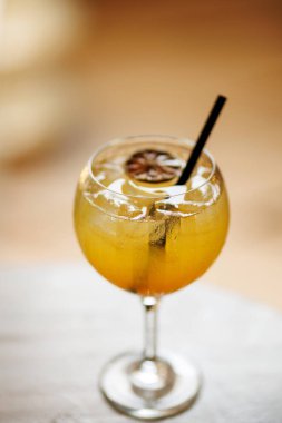 Kurutulmuş narenciye dilimlenmiş parlak turuncu kokteyl ve soğuk bardakta servis edilen saman. Tropikal içecekleri, yaz rahatlığını veya bar yaşam tarzını resmetmek için mükemmel..