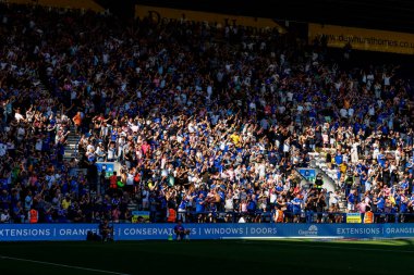 Preston, İngiltere - 16.08.2025: Maç sırasında stadyum standında tezahürat yapan büyük bir futbol taraftarı grubu. Kalabalık kollarını kaldırıyor ve güneş ışığı altında kutlama yapıyor..