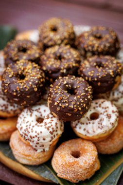 Çikolata, beyaz jöle ve bir yığın serpiştirilmiş çeşitli donutların yakın çekim görüntüsü.