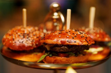 Tepside servis edilen susamlı hamburgerlerin yakın çekimi..