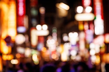 Yoğun bir şehir sokağından canlı renkleri ve parlayan daireleri gösteren odak dışı arkaplan.