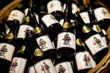 Osaka, Japonya - 15.11.2024: Beyaz ve altın etiketli çok sayıda küçük cam şişe Japon pirinç şarabı..
