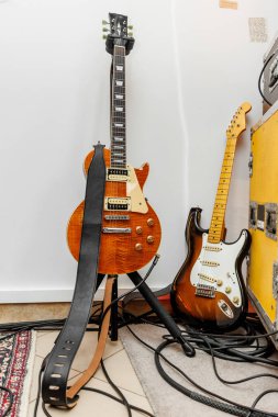 İki elektro gitar, kablolar ve kasalarla bir prova stüdyosunda..
