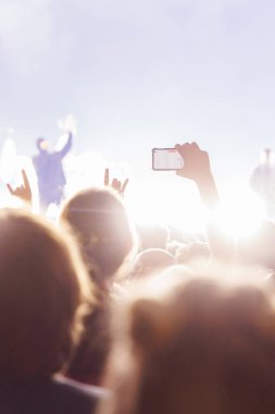 Soyut, dikey odaklı olmayan bir şekilde açık hava konserinden zevk alan bir seyircinin görüntüsü, metin örtüşmeleri için mükemmel..