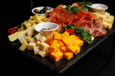 Bir toplanma için çeşitli peynir, salam, jambon ve zeytin çeşitleriyle dolu tabaklar..