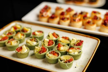 Seramik tabakta krema, somon ve limon dilimleriyle dolu yeşil lezzetli tartlar..