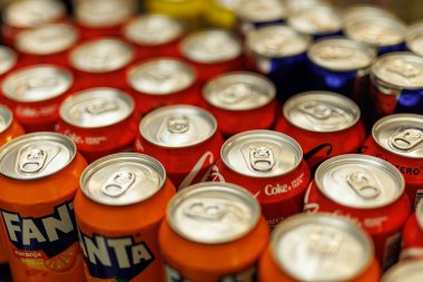 Yüksek açılı, turuncu ve kırmızı çeşitleri de içeren renkli alüminyum soda kutularını gösteren bir çekim..
