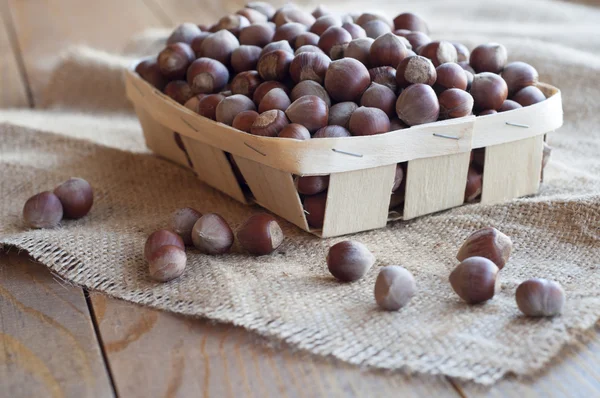 Huzelnuts dans un panier en osier sur une table . — Photo