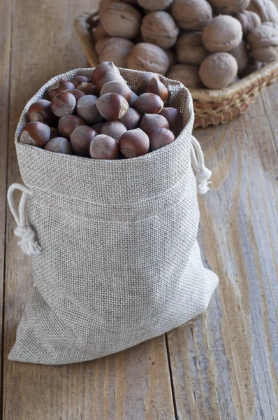 Avellanas y nueces sobre una mesa de madera . — Foto de Stock