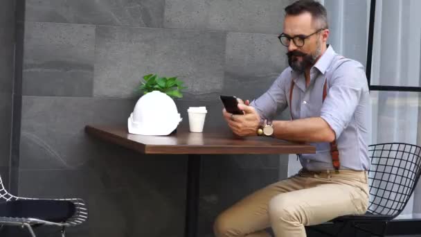 Ingegnere Barbuto Siede Caffè Americano Tiene Mano Uno Smartphone Legge — Video Stock