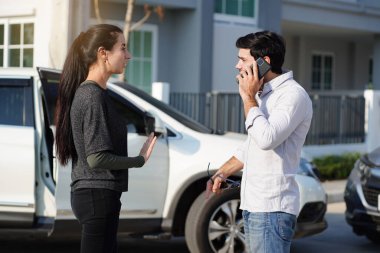 Handsome man quarreled with a beautiful woman in a car accident and used his smartphone to call for insurance and claim the damage.  clipart
