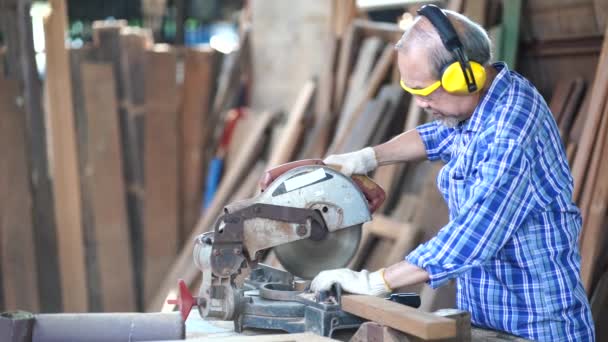 シニア大工は熟練して経験があります 手袋を着用する準備 マスクを着用 木工の準備 彼のワークステーションで家具を修復 — ストック動画