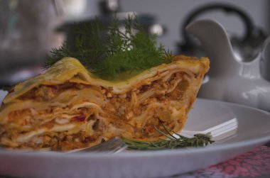 Ahşap bir arka planda kıyma, domates sosu ve dereotlu ev yapımı lezzetli lazanya. Ev yapımı İtalyan yemekleri.