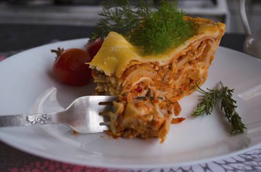 Ahşap bir arka planda kıyma, domates sosu ve dereotlu ev yapımı lezzetli lazanya. Ev yapımı İtalyan yemekleri.