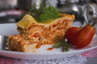 Ahşap bir arka planda kıyma, domates sosu ve dereotlu ev yapımı lezzetli lazanya. Ev yapımı İtalyan yemekleri.