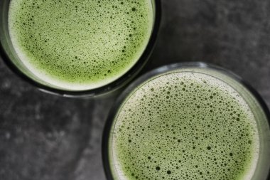 Üzerinde kibrit latte olan fincanı gri arka plan üstten makro fotoğraflı.