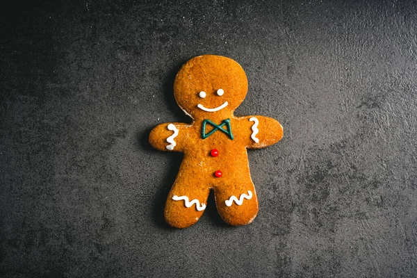 Gingerbread Man. christmas gingerbread cookie on dark background with candy top view. sweet dessert