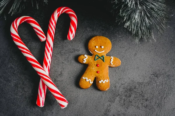 Gingerbread Man. christmas gingerbread cookie on dark background with candy top view. sweet dessert