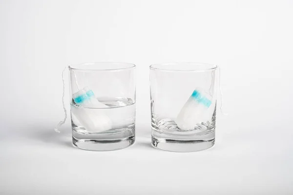 Dwa Tampony Miesiączki Szklanym Kubku Wodą Bez Wody Test Absorpcji — Zdjęcie stockowe