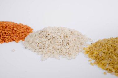 Farklı türde pirinç: kahverengi, yabani, basmati, kırmızı mercimek ve beyaz arka planda Tibet pirinci. makro fotoğraf. sağlıklı vejetaryen yemeği. ulusal Asya yemeği