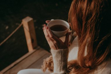 Güzel genç kız göl kenarında doğada çay içer. Şehirden çok uzak bir yerde, göz kamaştırıcı bir yerde dinlenen bir kadın. İnsansız kişisel izolasyon tatili
