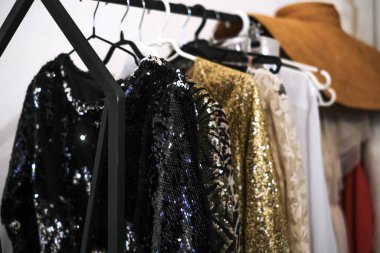 Soyunma odasındaki askıda parlak, parlak kokteyl elbiseleri. Yeni yıl partisi için yeni yılbaşı koleksiyonundan 2021 moda elbise.