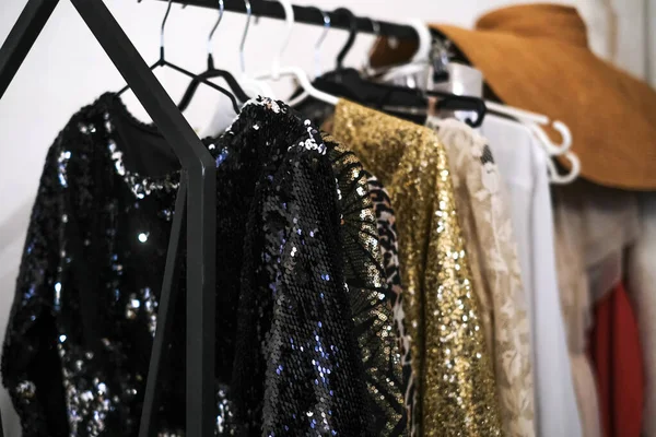 Soyunma odasındaki askıda parlak, parlak kokteyl elbiseleri. Yeni yıl partisi için yeni yılbaşı koleksiyonundan 2021 moda elbise.